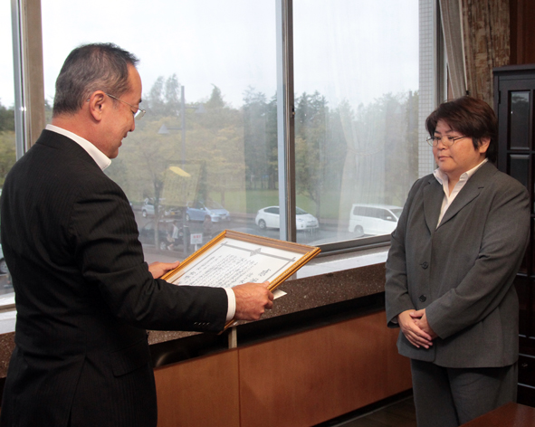 表彰状を読み上げる市長と、向かい合うようにして立っている佐々木さんの写真