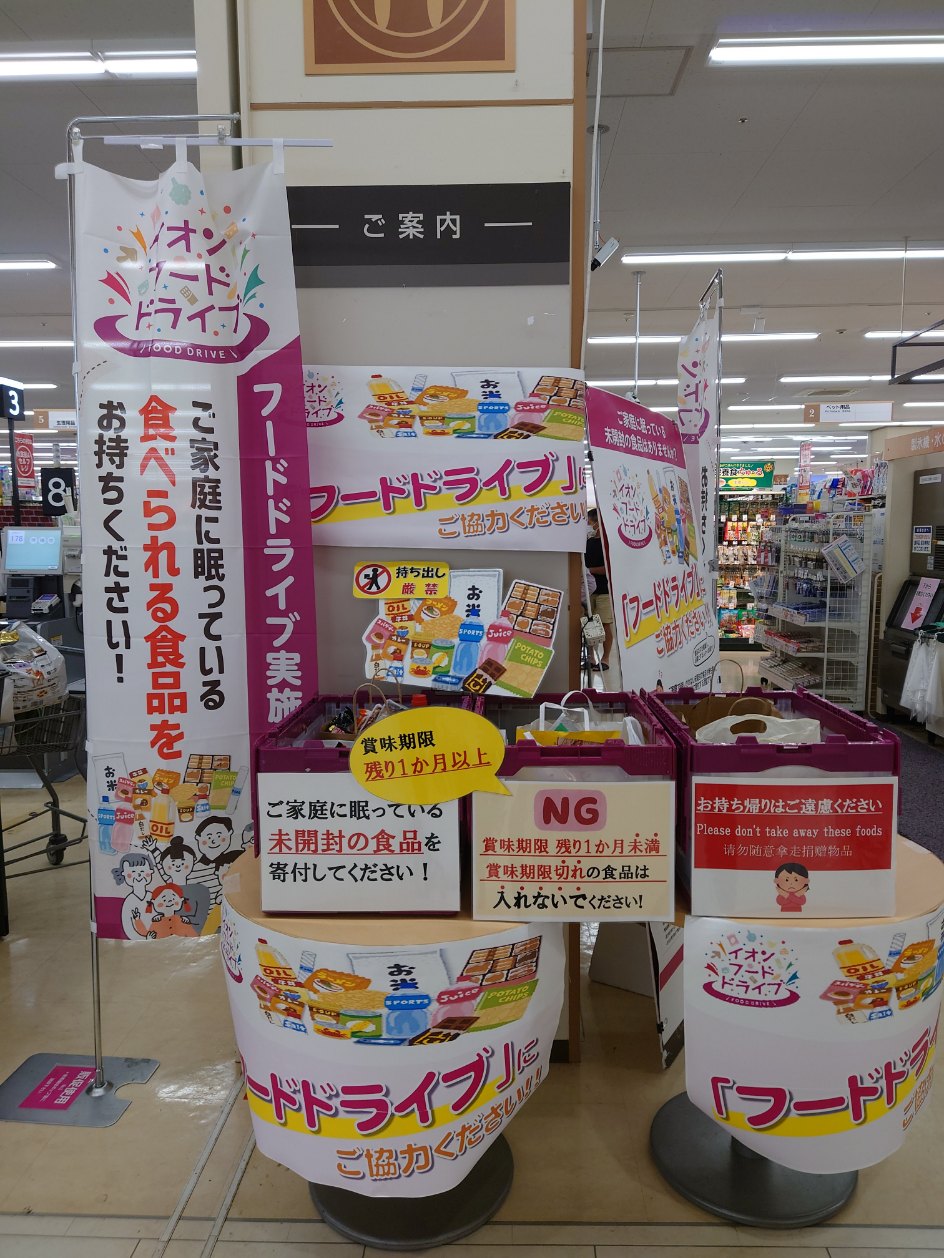 フードドライブののぼりと3つの回収箱が設置されているイオン岩見沢店内の写真