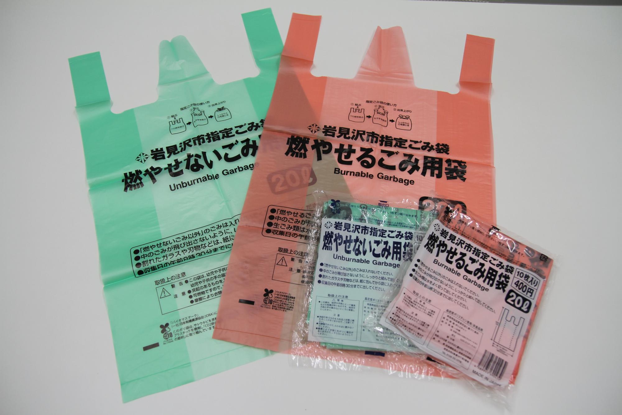 ピンクの燃やせるごみ用袋と緑の燃やせないごみ用袋を並べた写真
