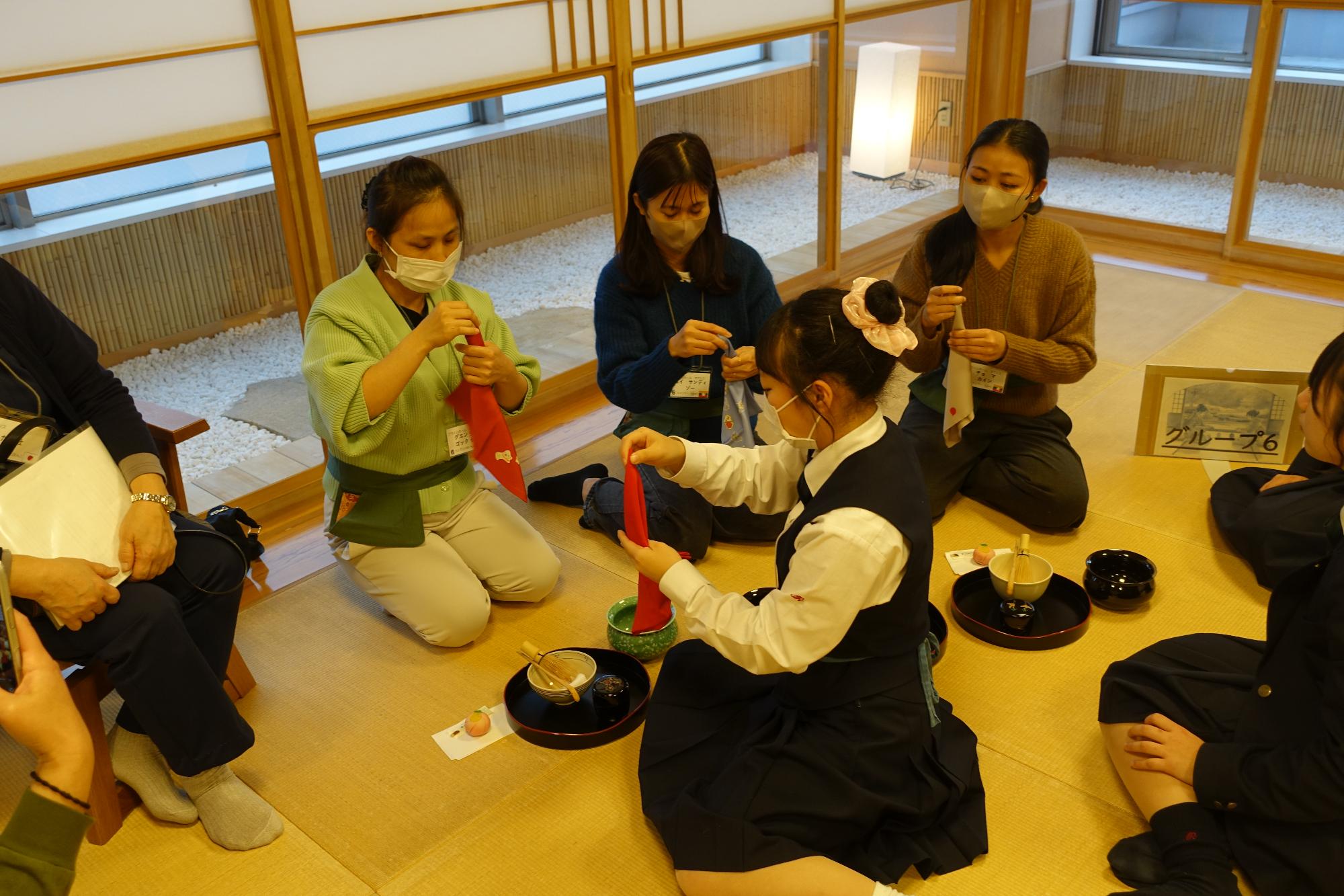 ふくさの畳み方を教わる外国人