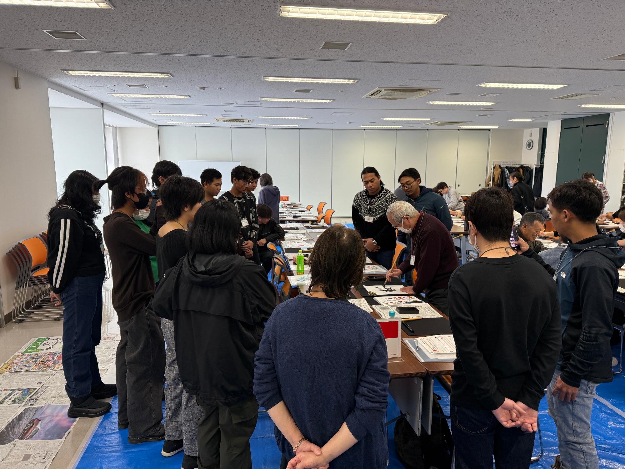 書道講師のお手本を見ている外国人の様子