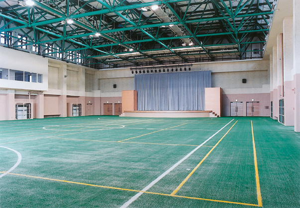緑色の人工芝にフットサルやテニスコートのラインが引かれたイベントホール赤れんがのイベントホールの写真