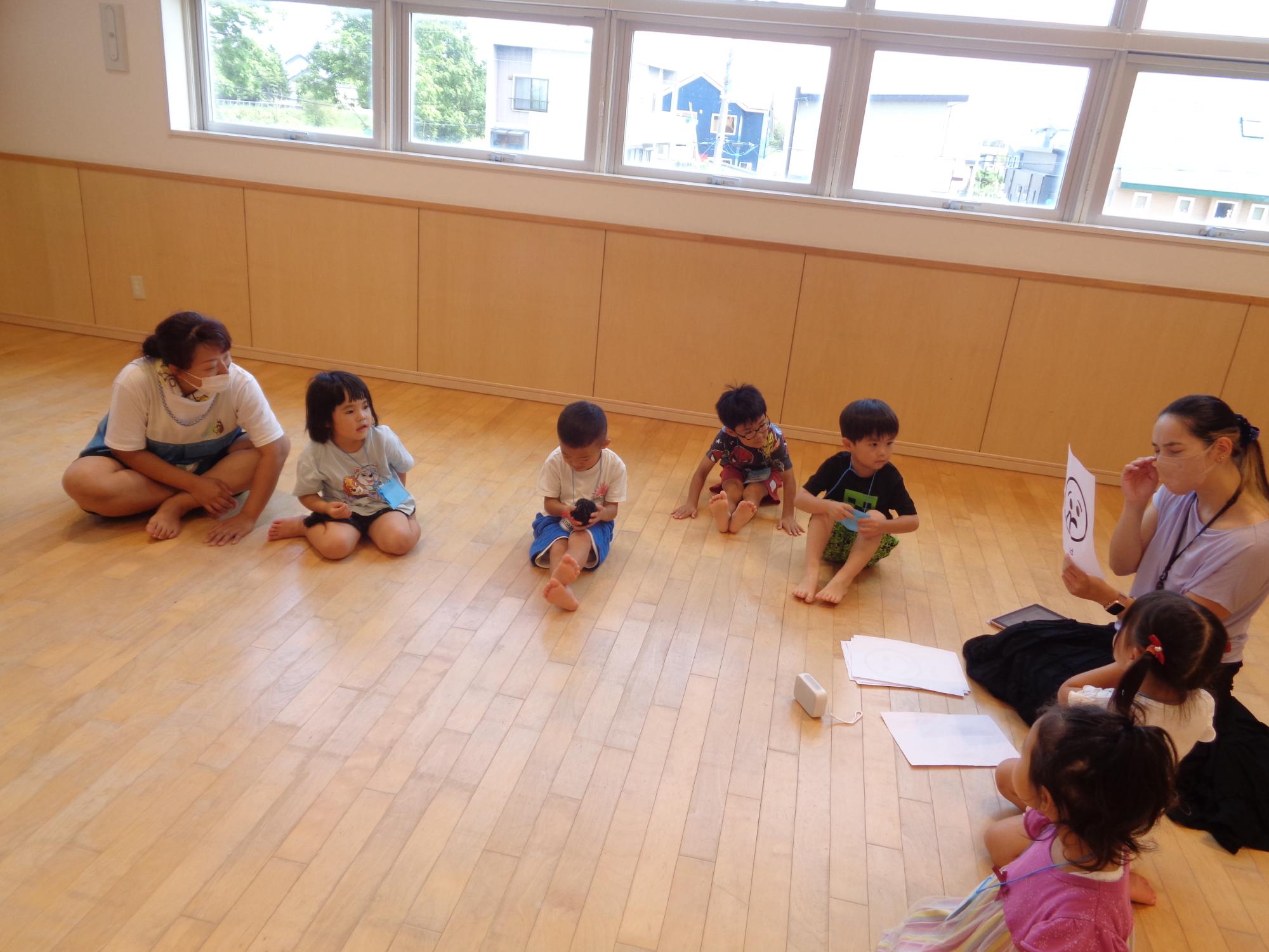 園児たちと輪になってゲームをする様子の写真
