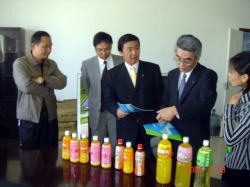 瀋陽潤田食品飲料有限公司を視察した岩見沢市長の写真。テーブルに11種類の飲料が並んでいる。