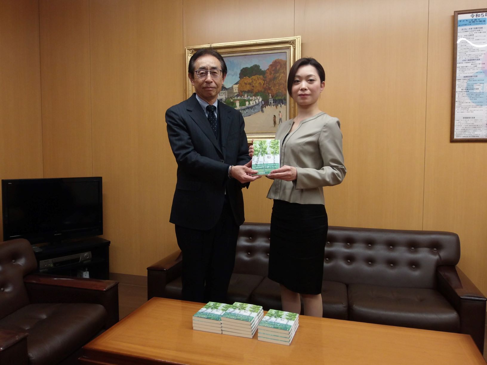 美山氏より教育長へ図書を手渡す様子