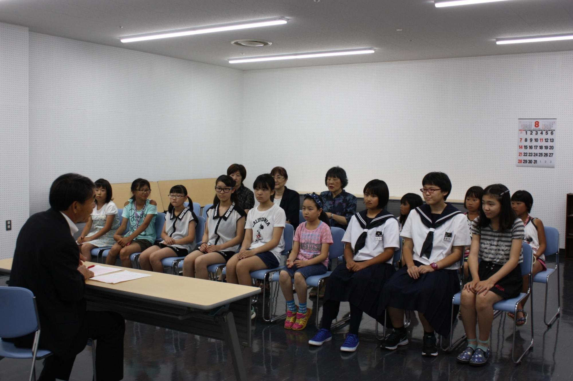 第54回岩見沢地区珠算競技大会兼全道珠算競技大会岩見沢地区予選上位入賞みなさんと教育長が向かい合い話をしている様子の写真