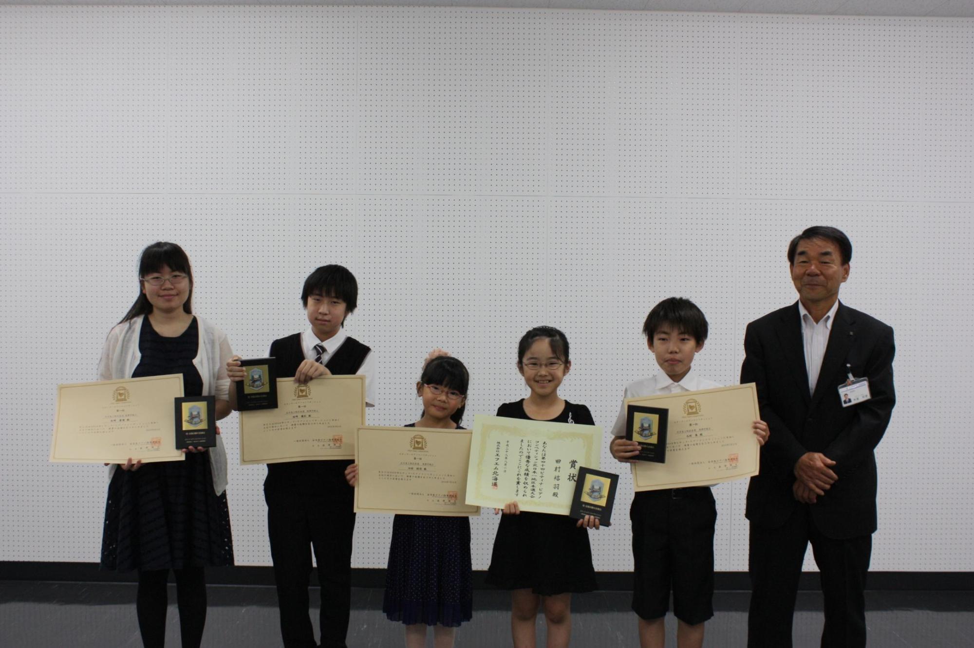 賞状と盾をもった上位入賞者のみなさんと教育長の写真