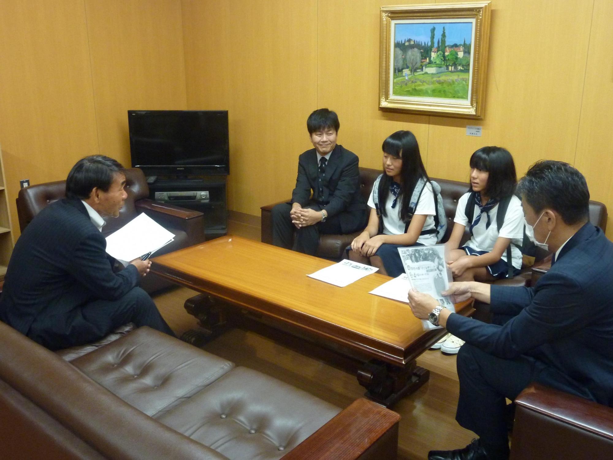 机を囲み教育長と話す三上さんと平井さんの写真