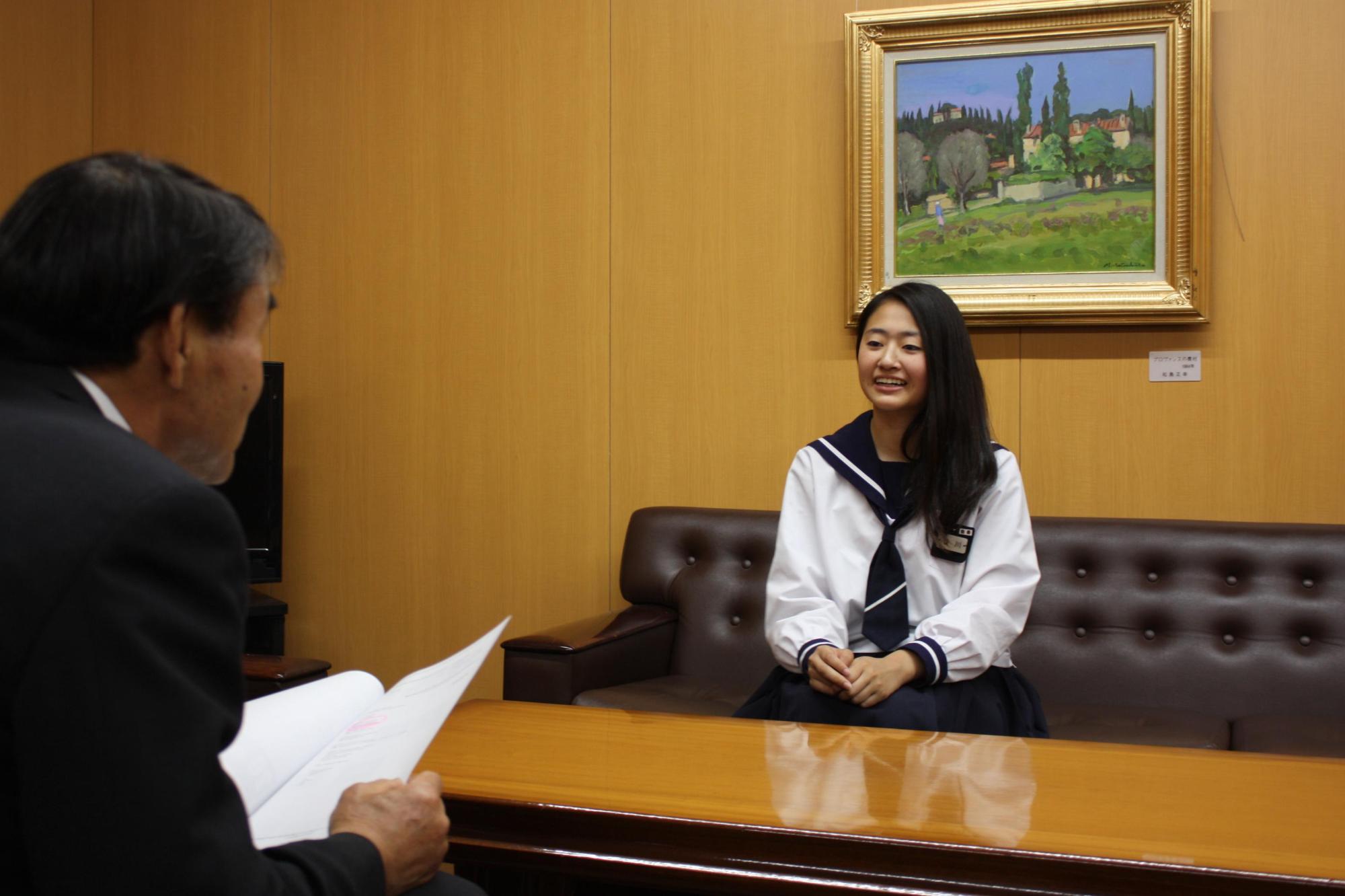 教育長と向かい合い笑顔で話す谷川さんの写真