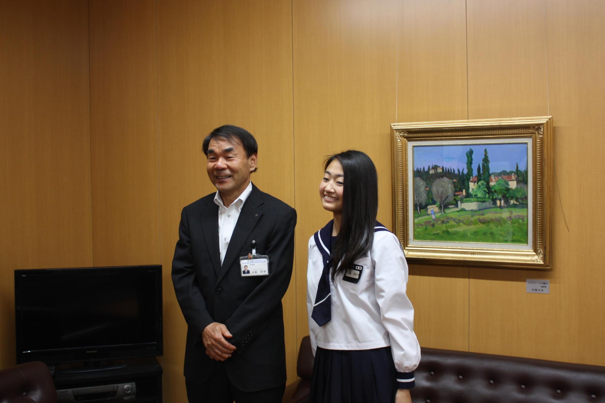 笑顔で並ぶ教育長と谷川さんの写真