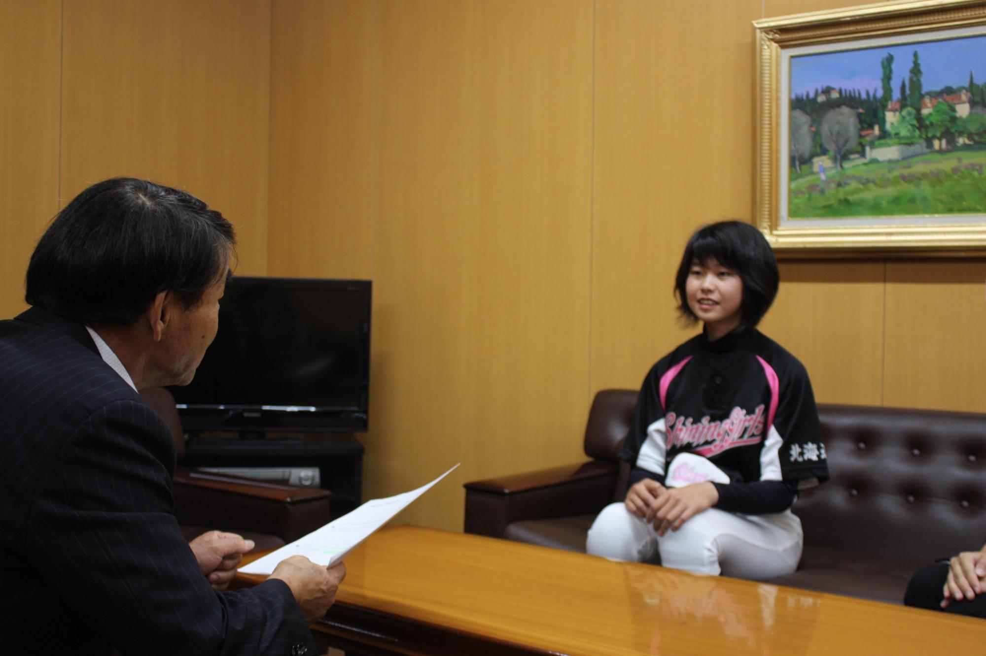教育長と向かい合い話す平井さんの写真