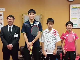 右から、ピンク色のユニフォームを着た女子生徒と、白いユニフォームを着た男子生徒と、黒いユニフォームを着た男子生徒と、スーツを着た男性が並んでいる写真