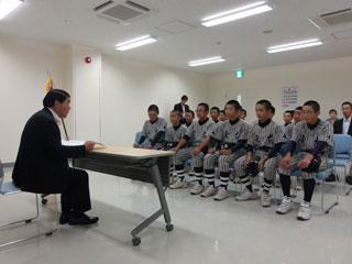 教育長の話を椅子に座って聞く野球のユニフォーム姿の男子生徒の写真