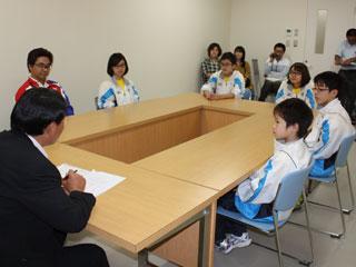 会議室の椅子に座って教育長の話を聞く生徒たちの様子