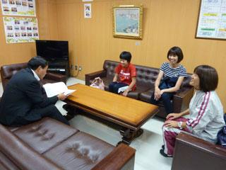 関係者と共に教育長の話を聞く女子生徒の写真