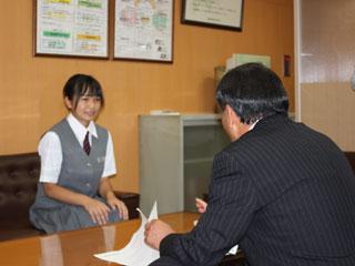 教育長の話を制服姿で聞く女子生徒の様子