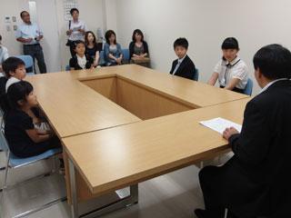 子供数人と保護者が、机を挟んで教育長と話をしている写真。