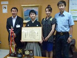 岩見沢市教育長、横田さんと他の2人が記念撮影をした写真。