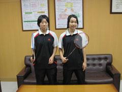 ラケットを持ったユニフォーム姿のバドミントン女子選手2名のツーショット写真