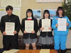 応接室で男子生徒1名と女子生徒3名が賞状を手に持って笑顔で微笑んでいる写真