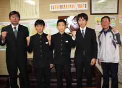 2人の代表生徒を真ん中にスーツ姿の男性2人と右側にジャージ姿の男性が写っている写真