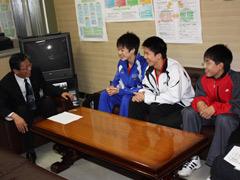 バドミントン選手権に出場する選手3人が教育長と話している写真