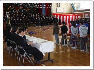 飾りつけられたステージに揃って立つ卒業生と向かい合うように立つ在校生たちの写真