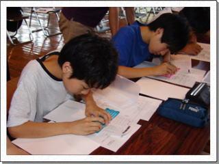 点字の枠を使って紙に点字を打っている様子の2名の男子生徒の写真