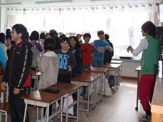 教室で翔太さんが笑顔で身振り手振りして体を動かしているのを真似しながら笑顔で体を動かしている子どもたちの写真