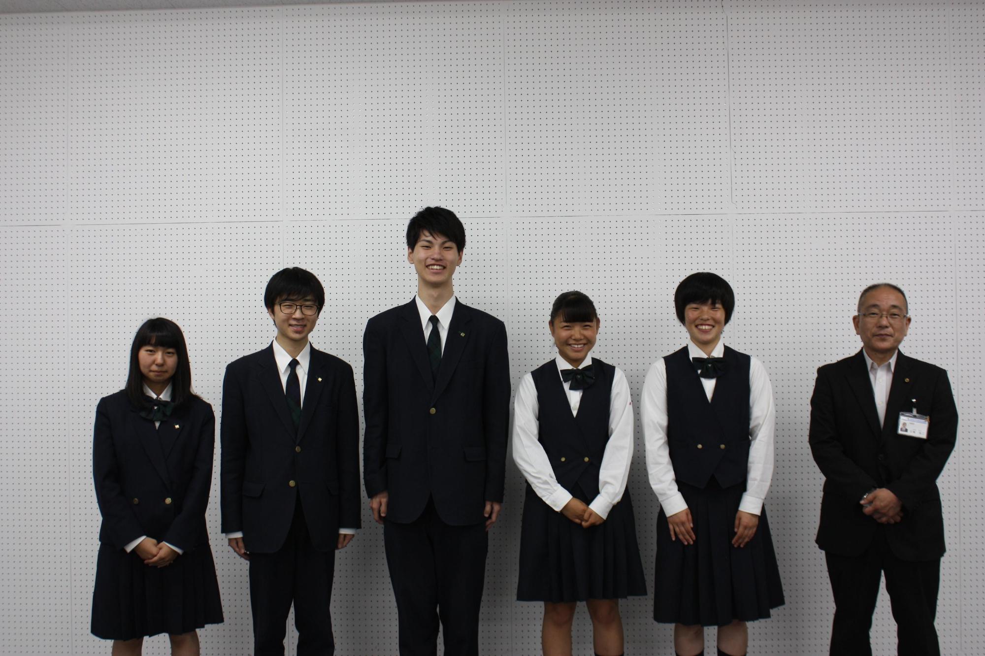 立ってポーズをとる全国大会出場のメンバーたちと教育長の写真