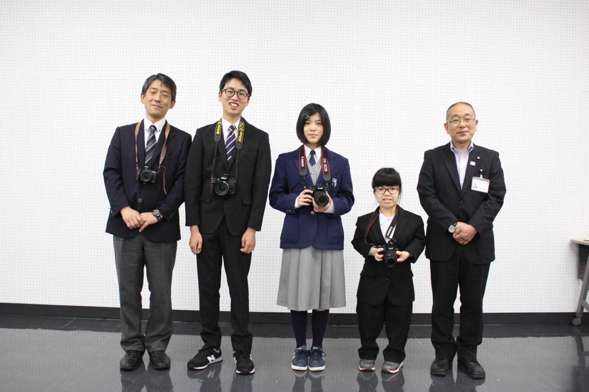 立ってポーズをとる全国写真大会出場の看護学校のメンバーたちと教育長の写真