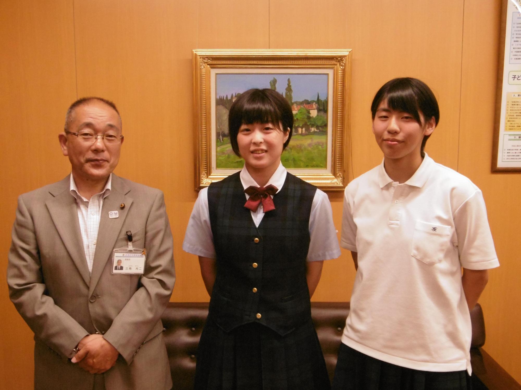 教育長と並んだバトミントン全国大会出場の女子高校生2人の写真