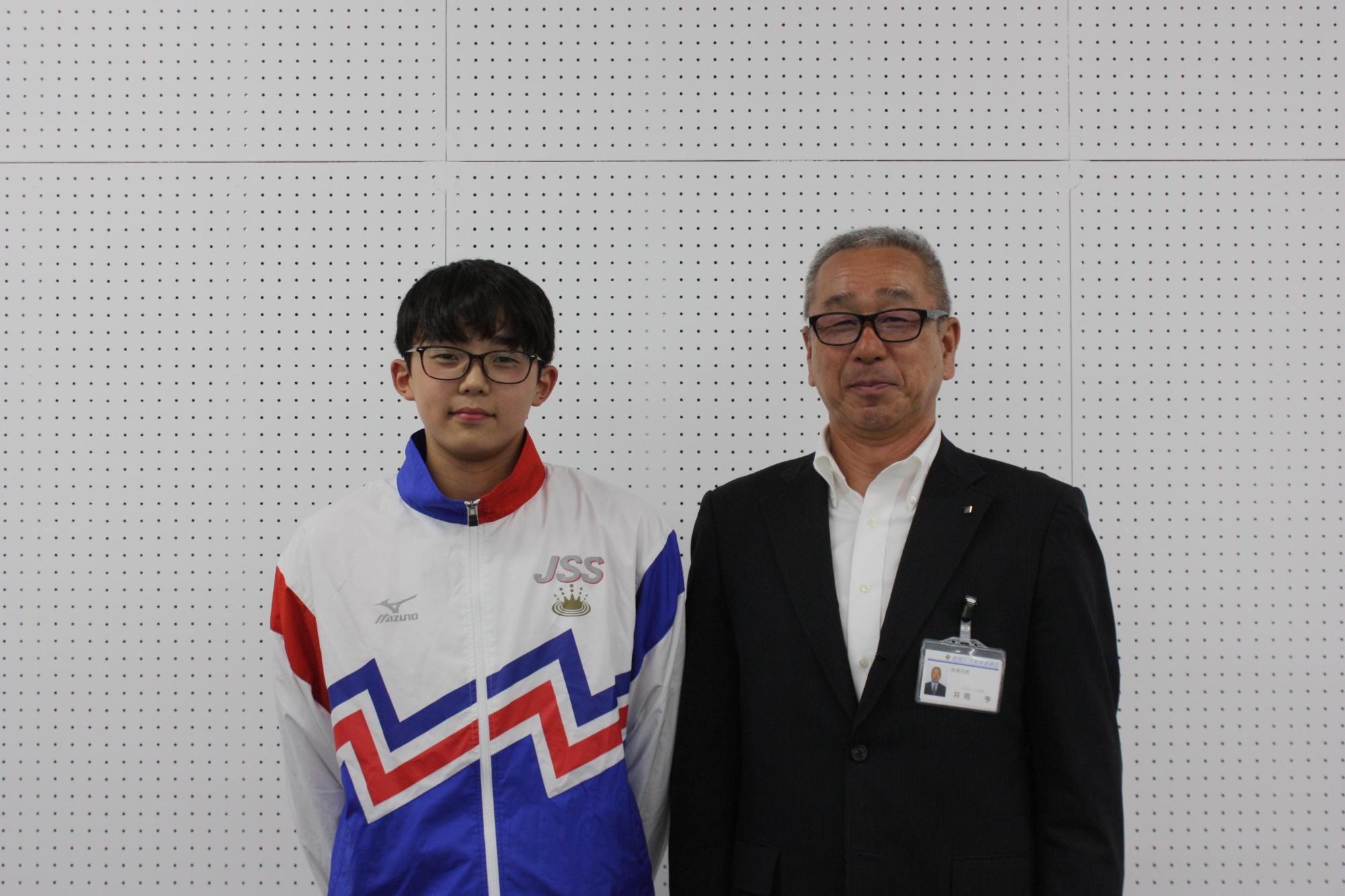 夏季水泳大会に出場する学生と教育長が横に並んだ写真