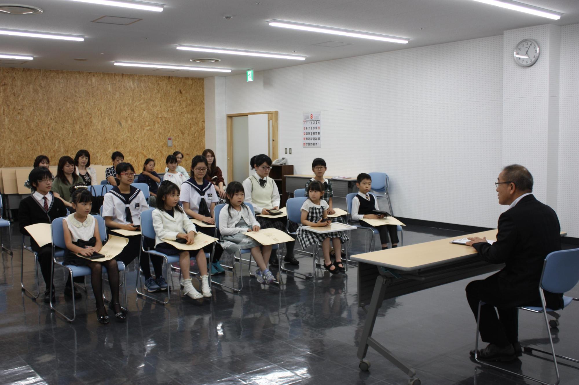 ピティナ・ピアノコンペティション全国大会に出場する学生と教育長が対面して座る写真