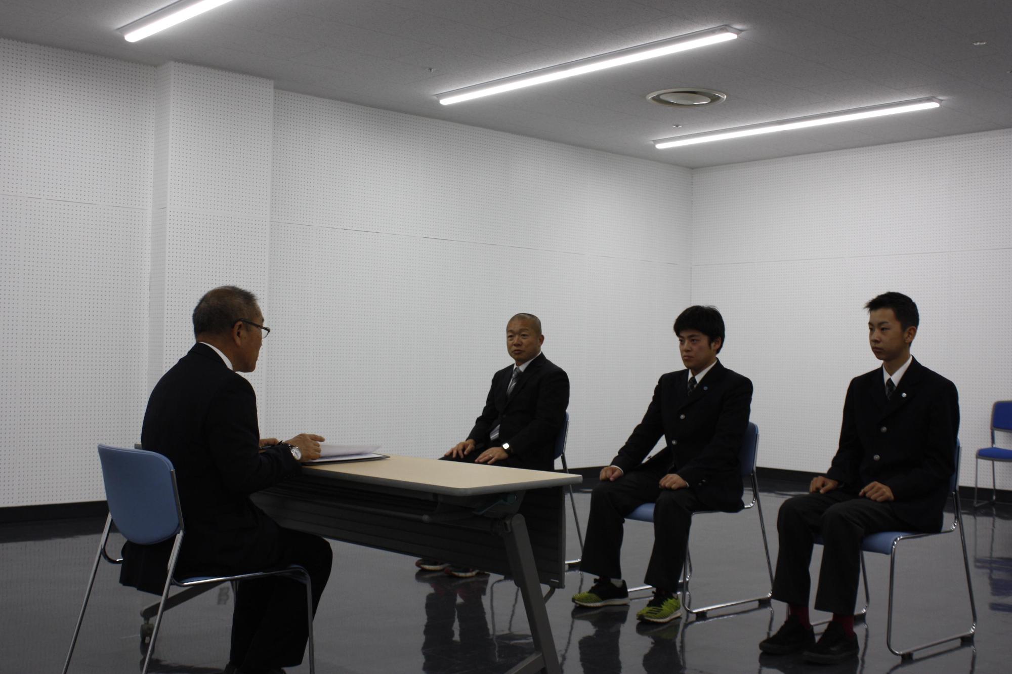 教育長に表敬訪問している男子ソフトボールの選手たちの写真