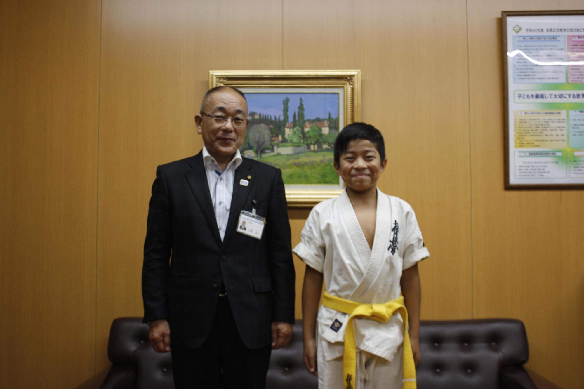 教育長と並んでいる黄帯の空手少年の写真