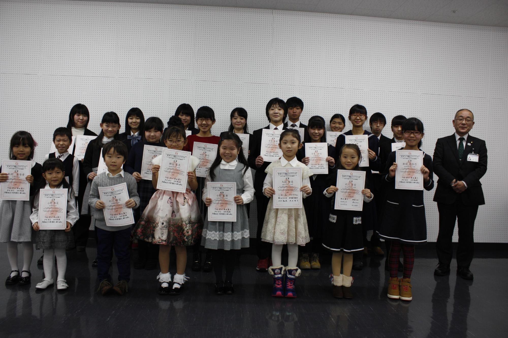 教育長とピアノのコンクールに出る学生が並んで写っている写真