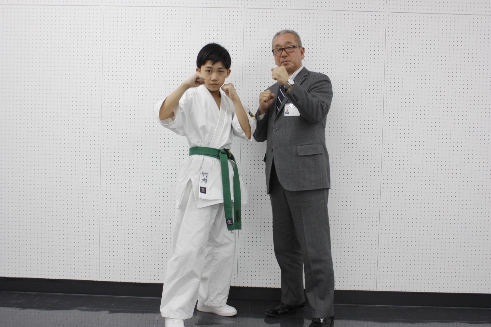 教育長の横で構えをする学生の写真
