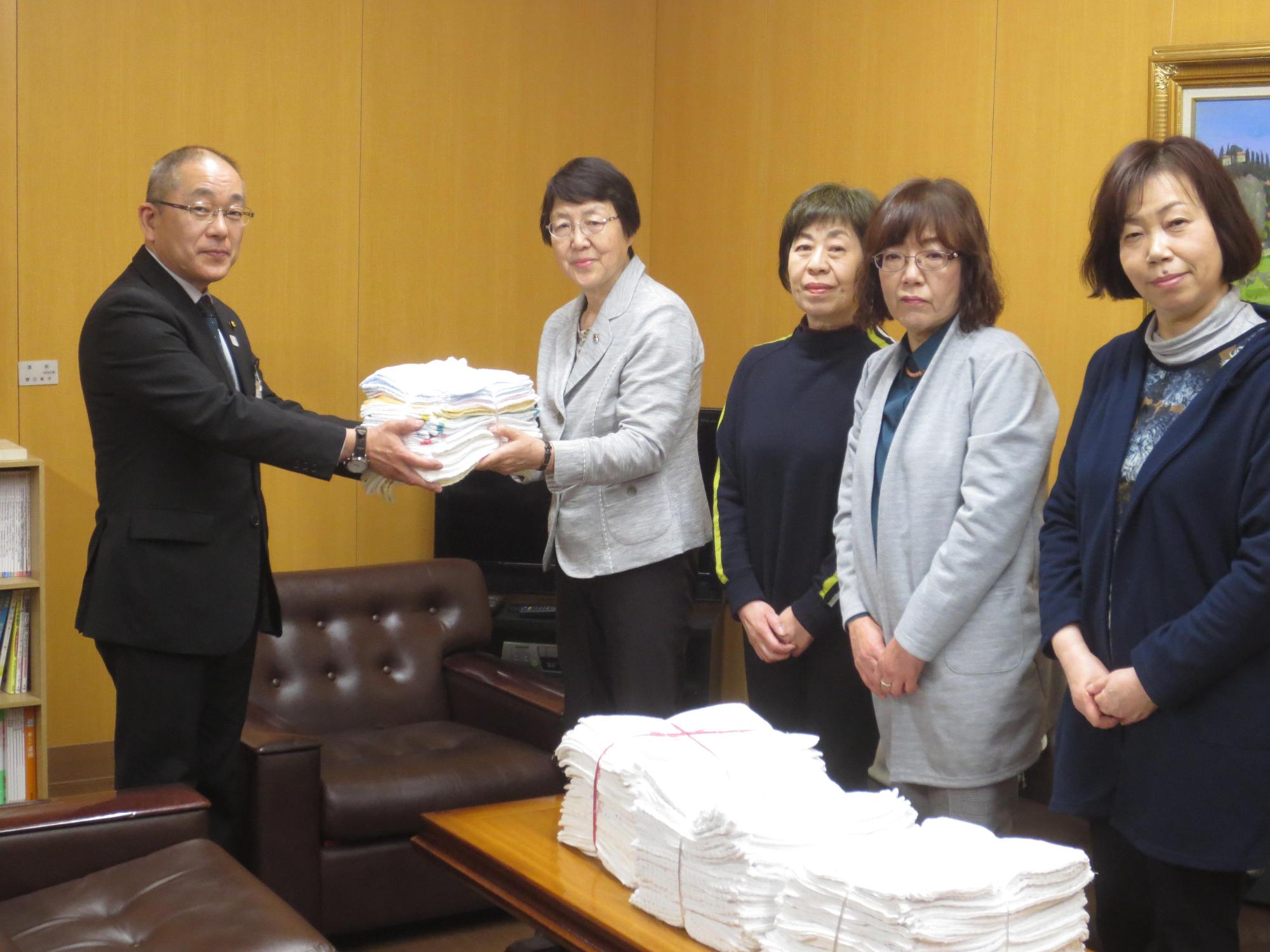 教育長が更生保護女性会からの雑巾の寄贈を受けている写真