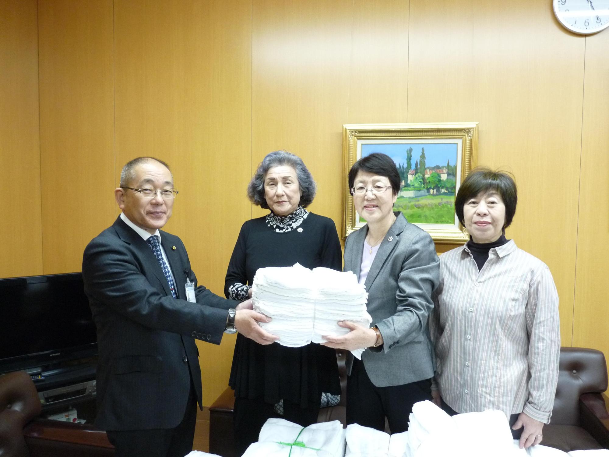 教育長が更生保護女性会からの雑巾の寄贈を受けている写真