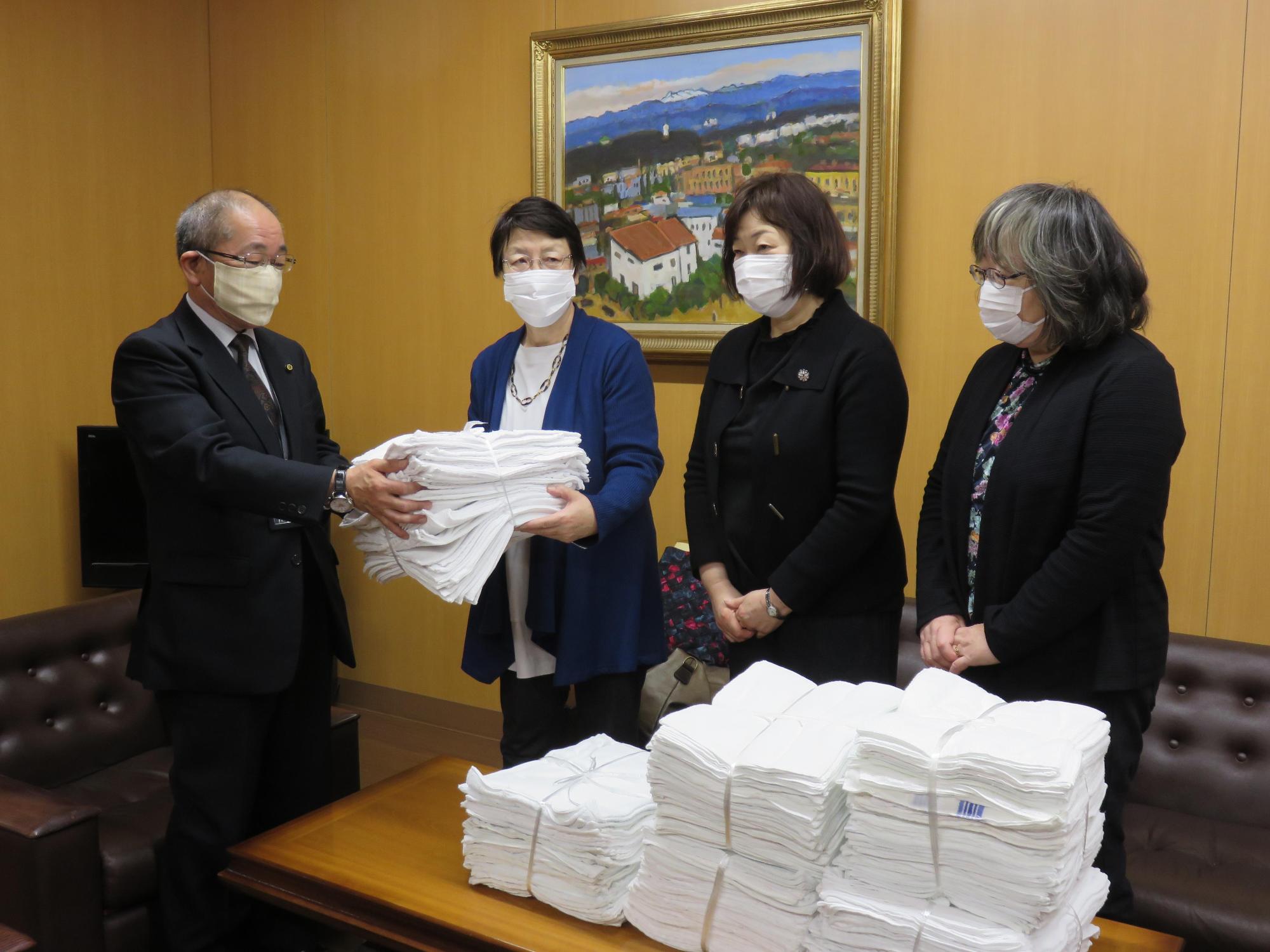 教育長が更生保護女性会からの雑巾寄贈を受けている写真