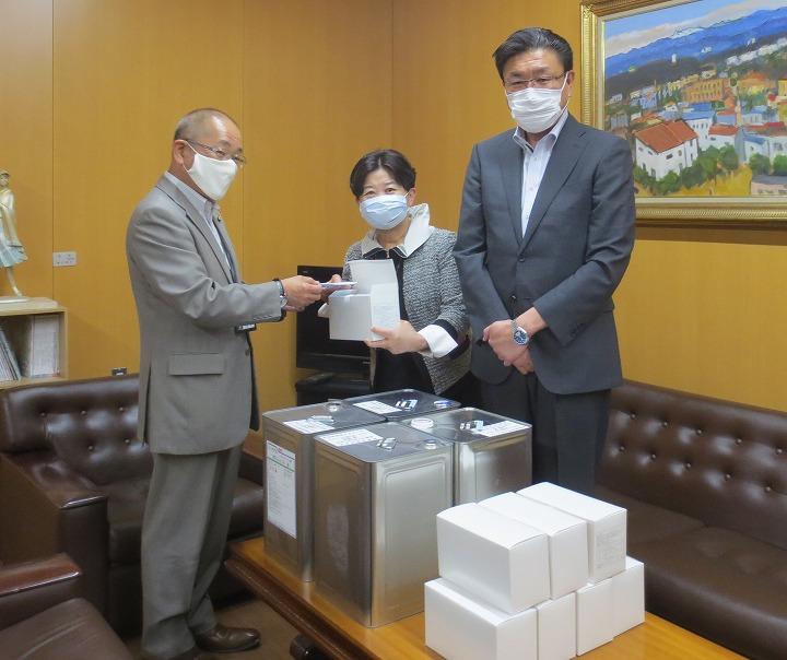 教育長が岩見沢学校薬剤師会から雑アルコール消毒液とマスクの寄贈を受けている写真