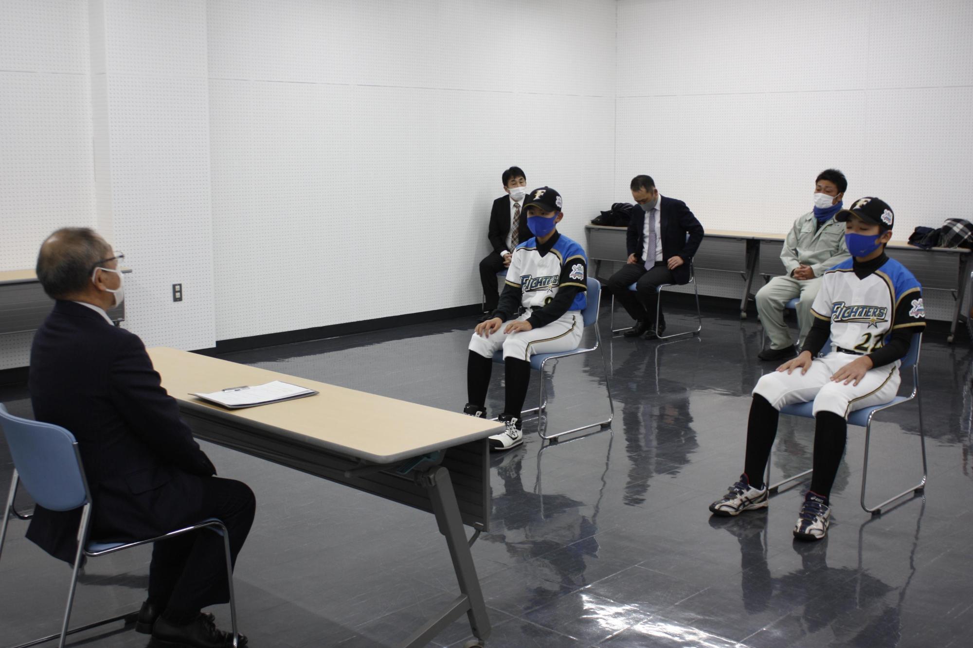 教育長と選手2名が歓談している様子の写真