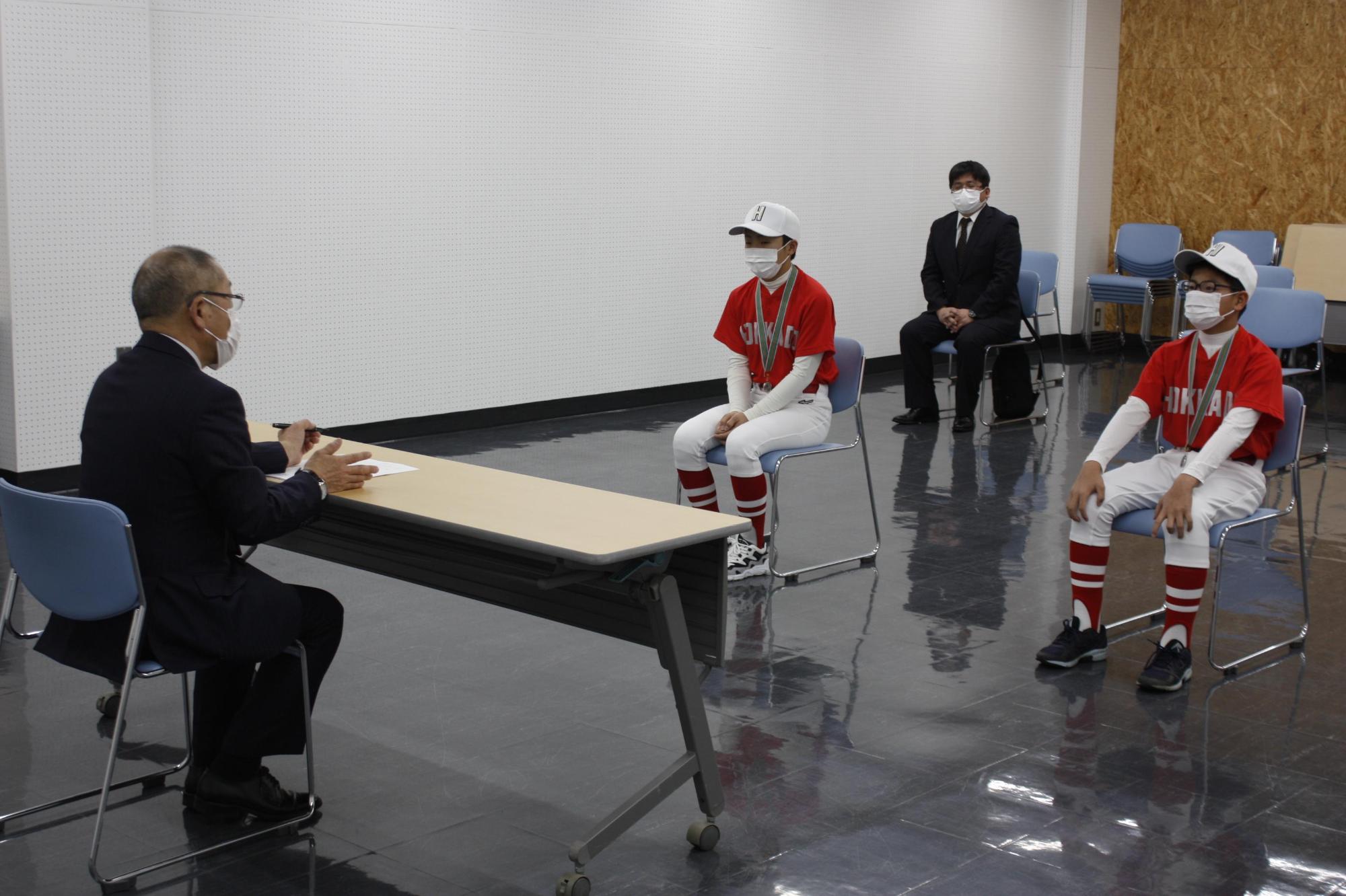 教育長と選手2名が歓談している様子の写真