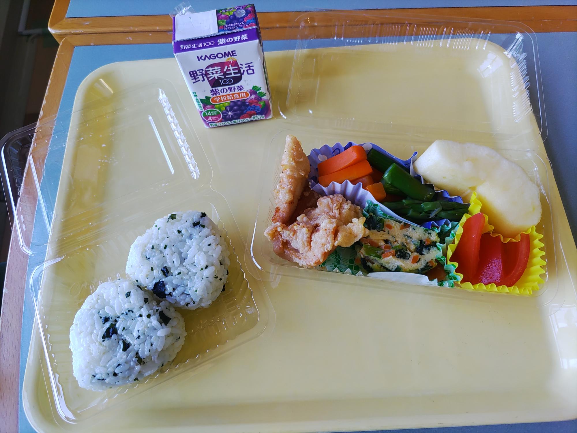 混ぜ込みわかめのおにぎり2個と唐揚げほうれんそうやにんじんが入った卵焼き、ピーマンと人参の炒め物、カットトマトとリンゴと小さな野菜ジュース