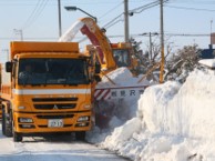 除雪車が道路に積もる雪を除雪している写真
