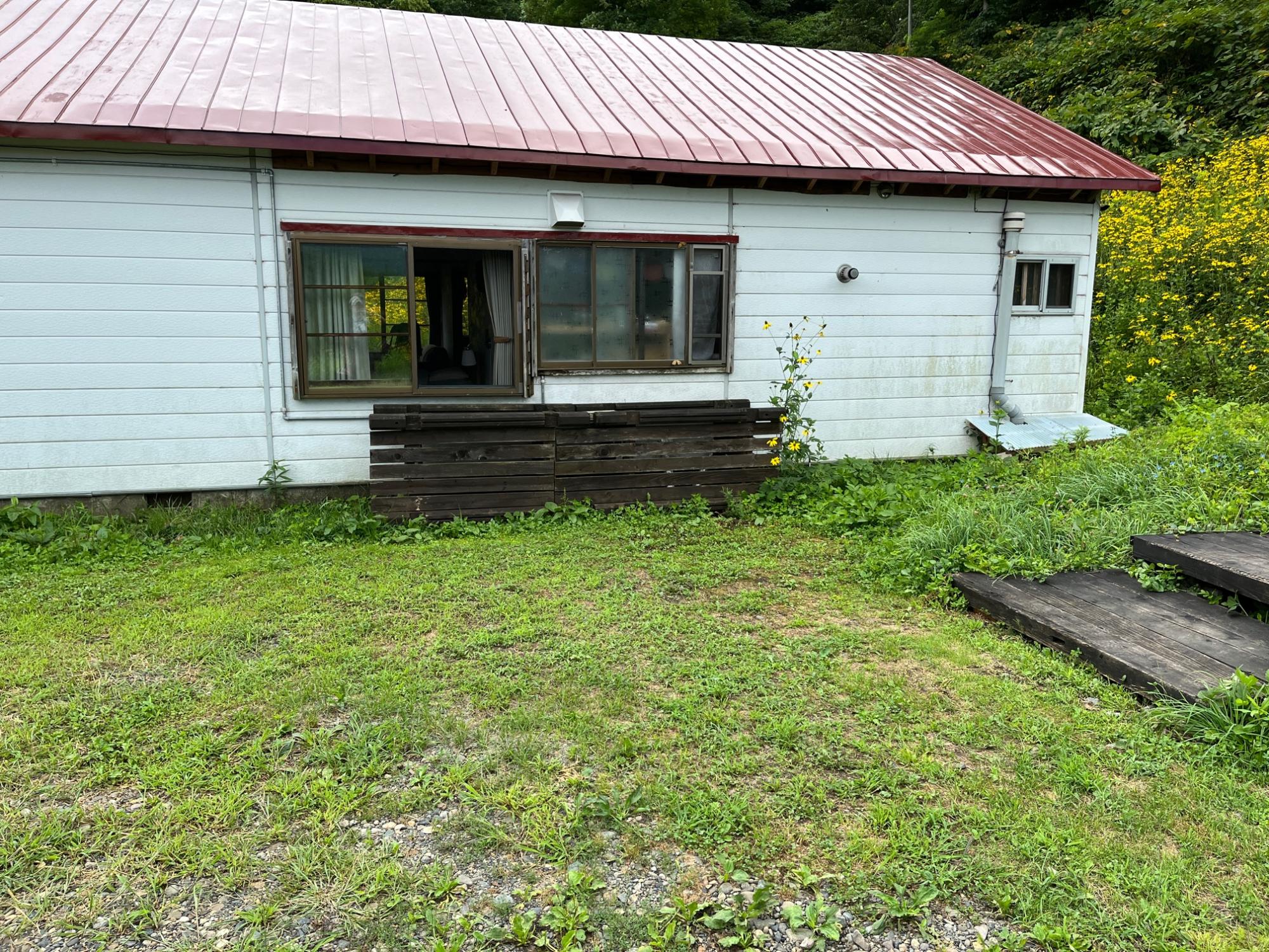 手前が緑の広場で、白い壁に赤い屋根のNORD houseの写真